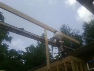 Carpenter setting a ridge beam over a new addition frame — Ice Dam Removal by Roofing Brothers in La Puente